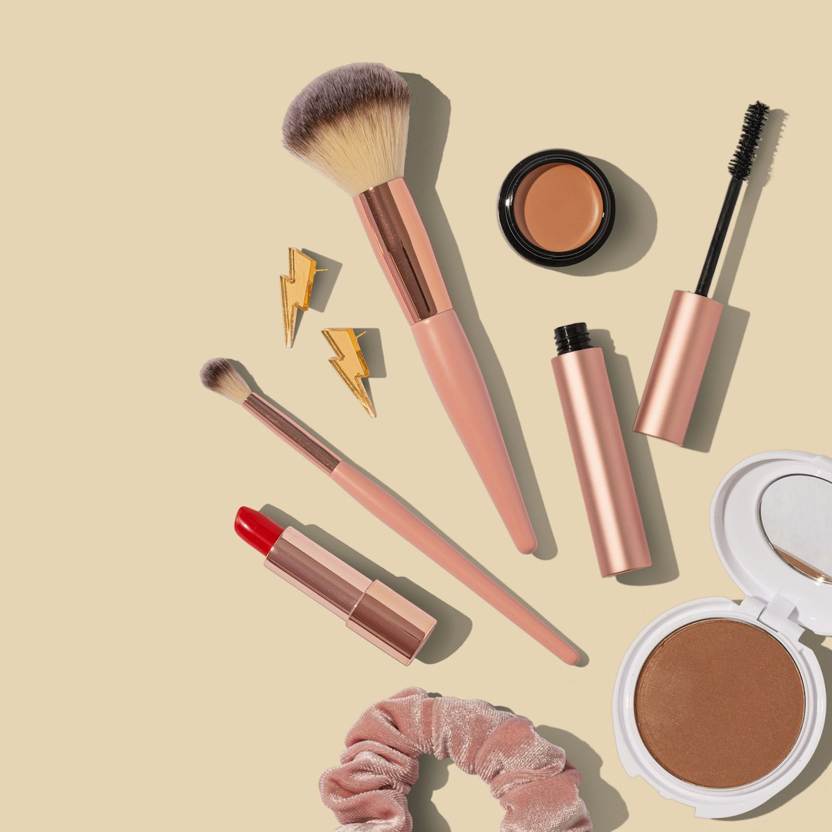 Eyeshadow palette with makeup brushes on a neutral background