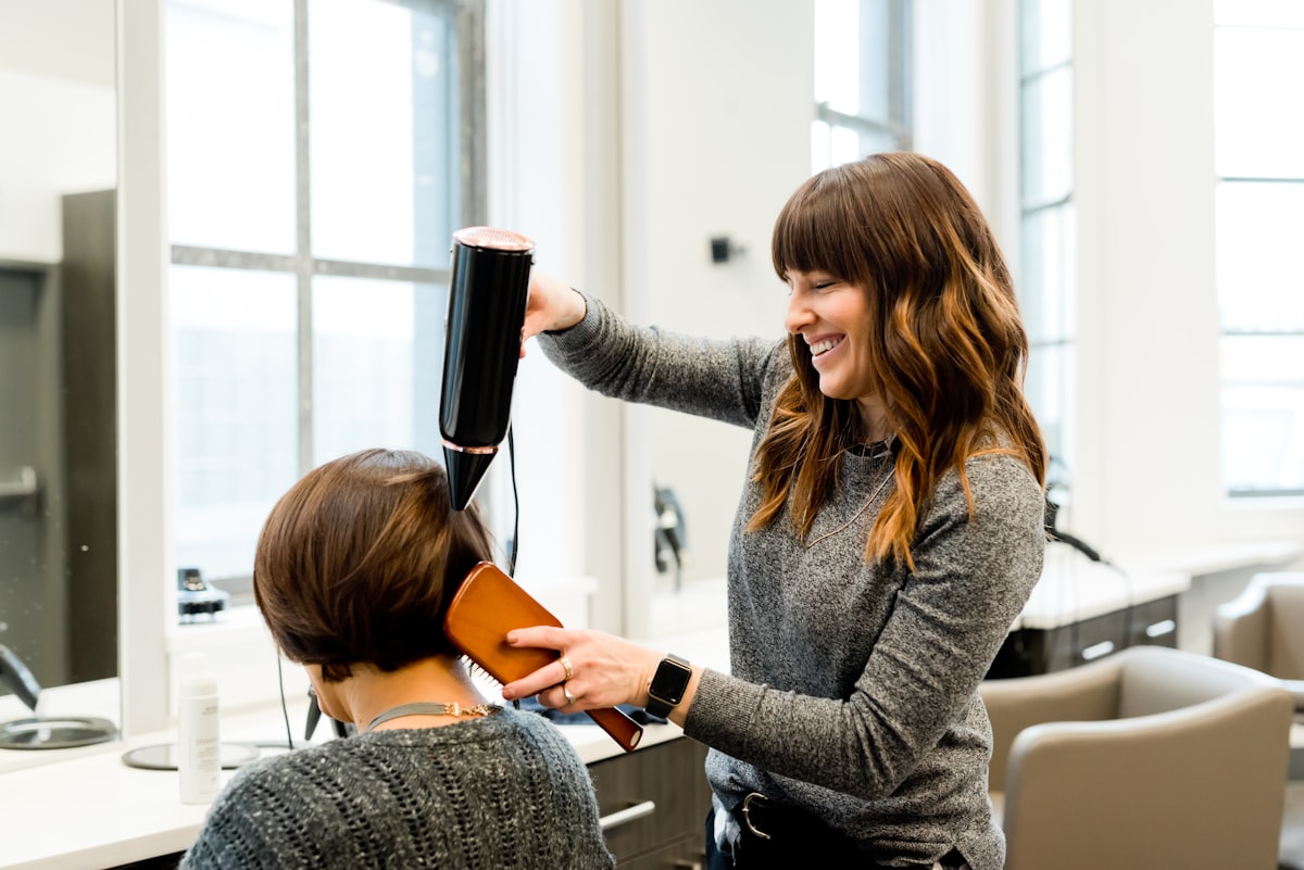 Hair stylist working gently with a client in a bright salon